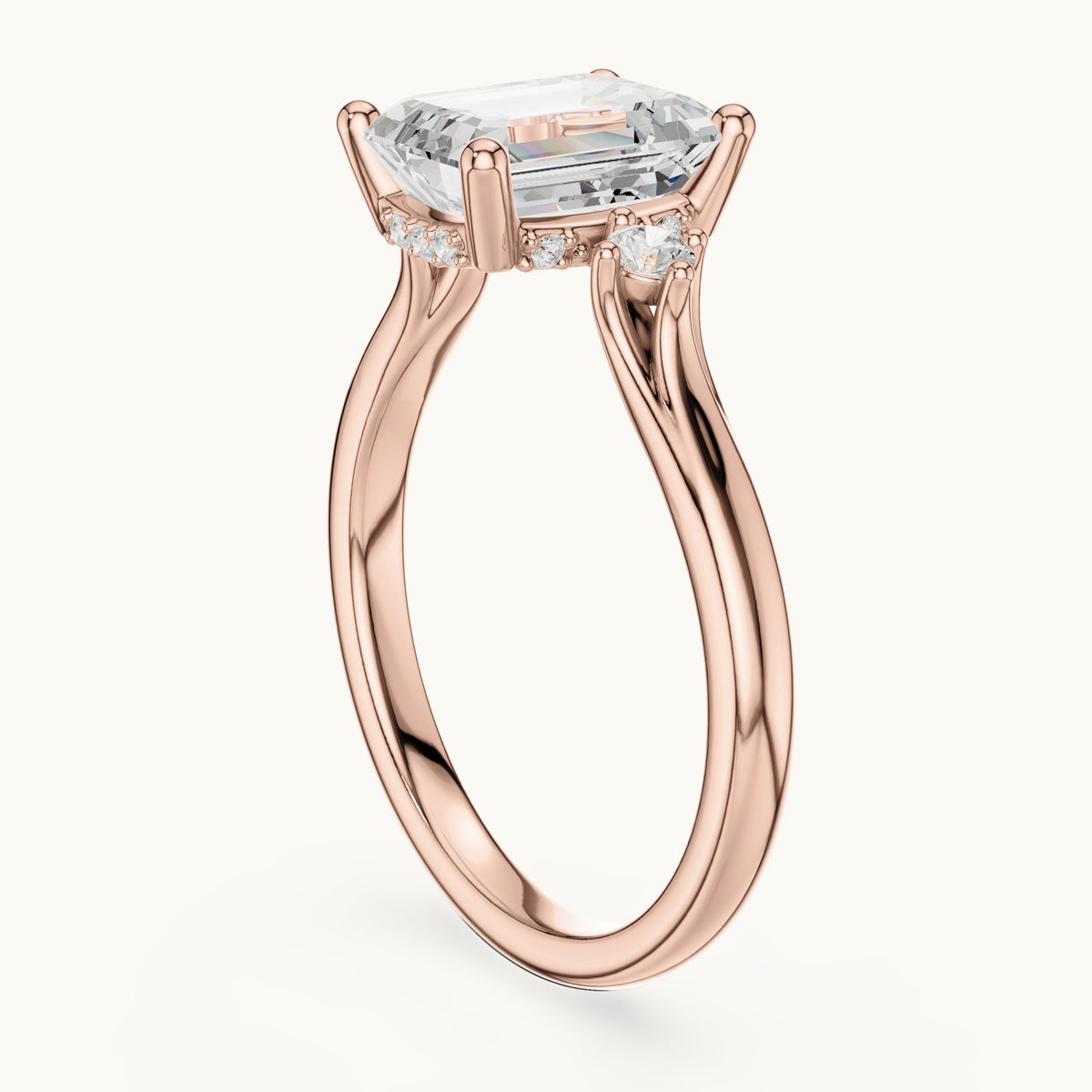Emerald-cut and round lab-grown diamond three-stone engagement ring with hidden halo in rose gold, 2.23 CT TW, view 1