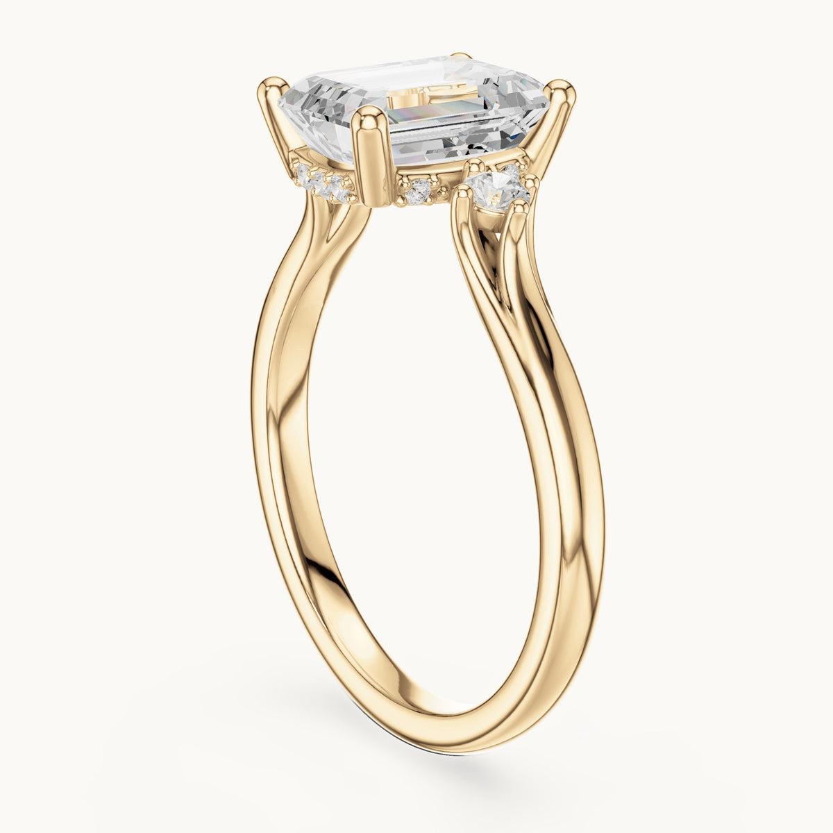 Emerald-cut and round lab-grown diamond three-stone engagement ring with hidden halo in yellow gold, 2.23 CT TW, view 1
