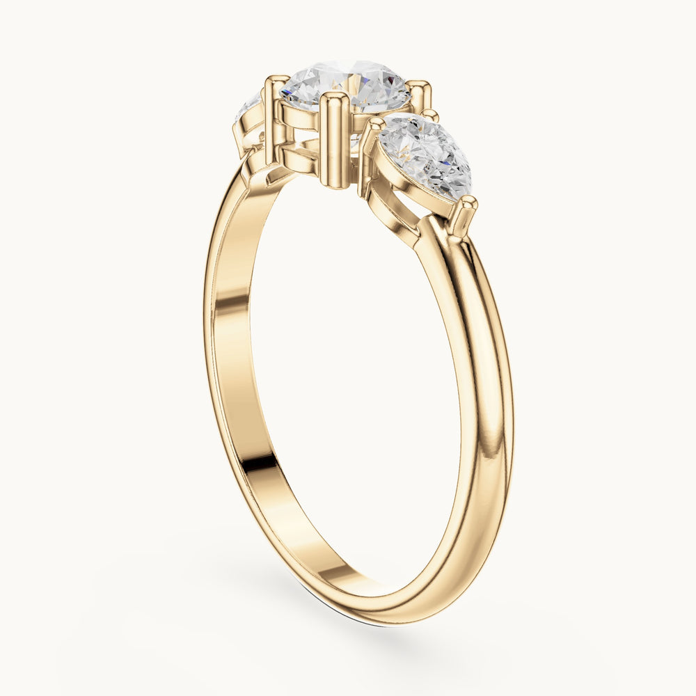 Round and pear lab-grown diamond three-stone engagement ring with side stones in yellow gold, 0.81 CT TW, view 1