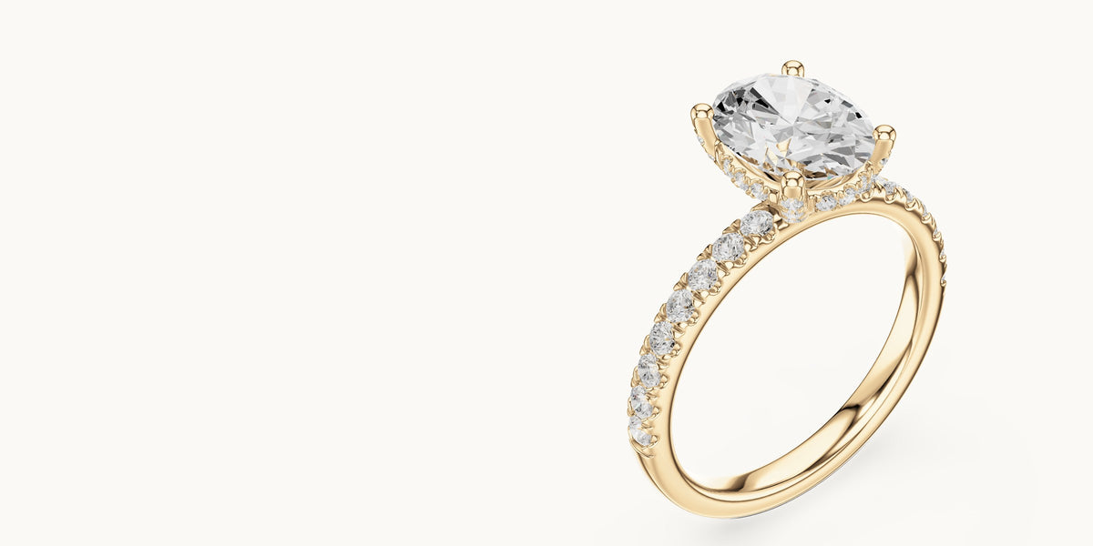 Oval lab-grown diamond engagement ring with hidden halo and pavé band in 14K yellow gold