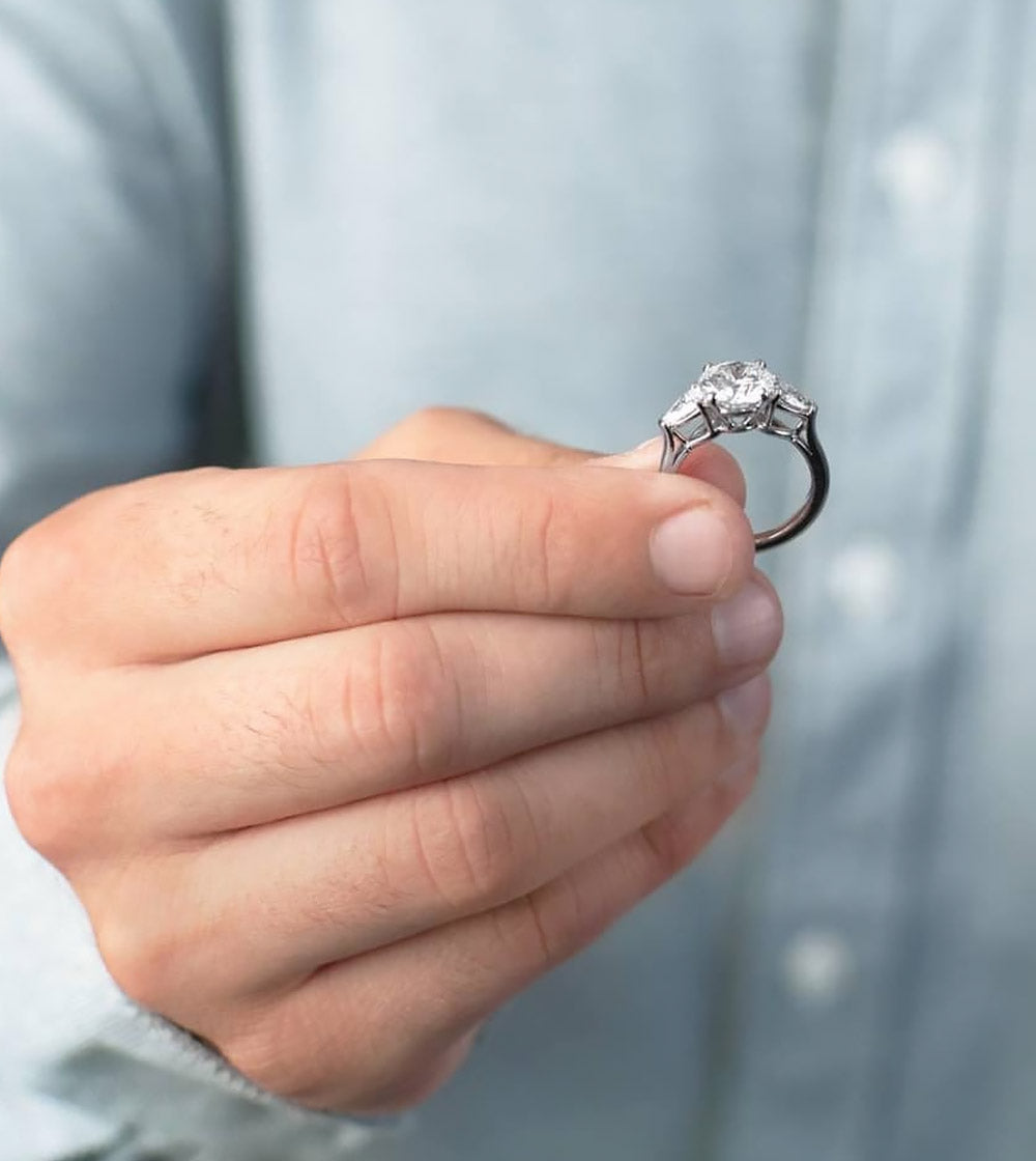 a man holding an engagement ring