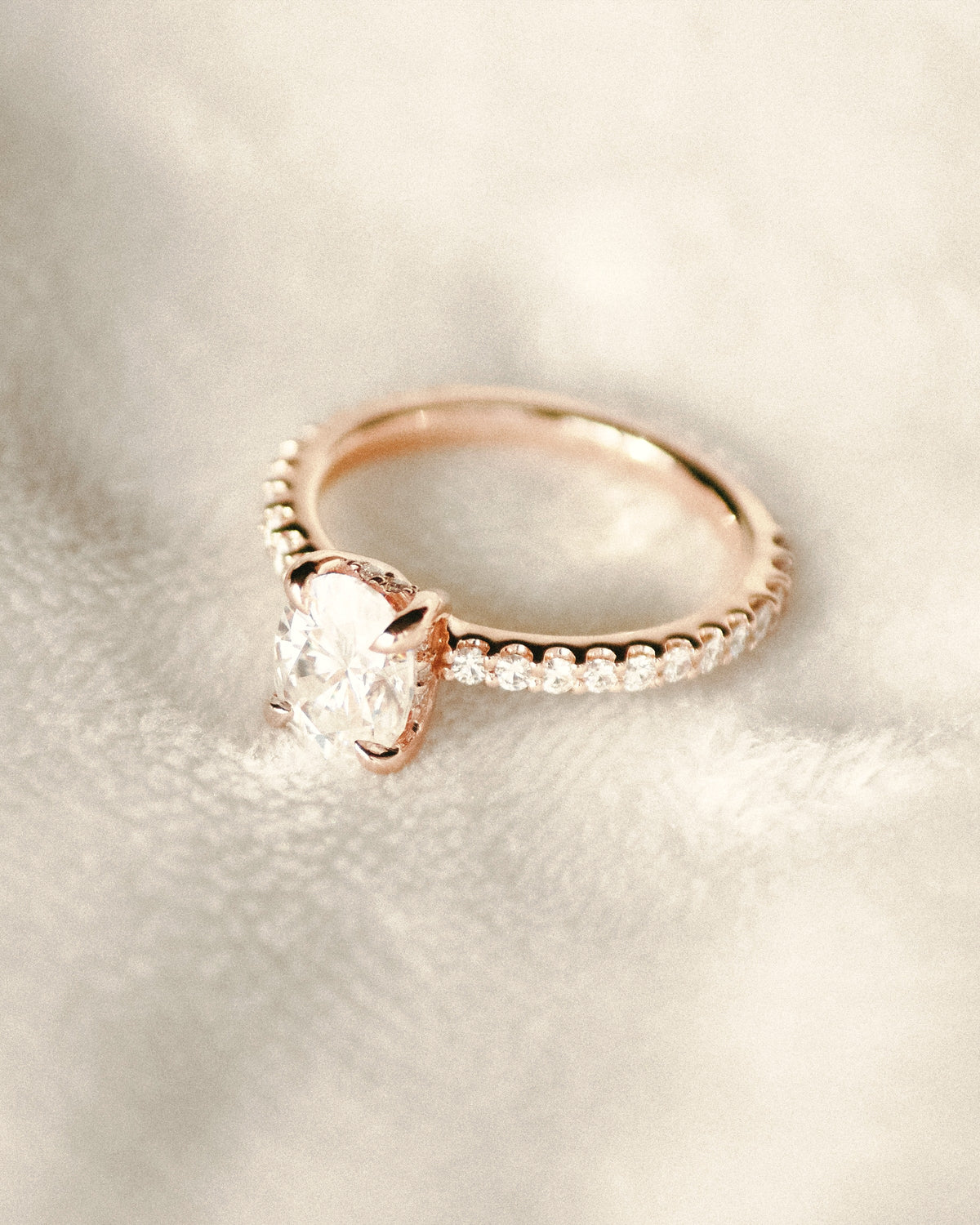 Rose gold oval solitaire ring with pavé band