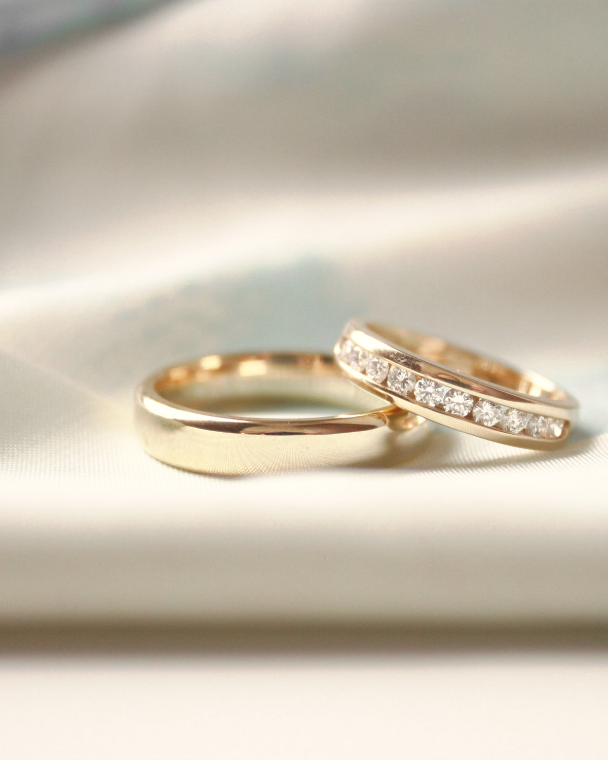 Gold wedding band and diamond channel-set band on satin