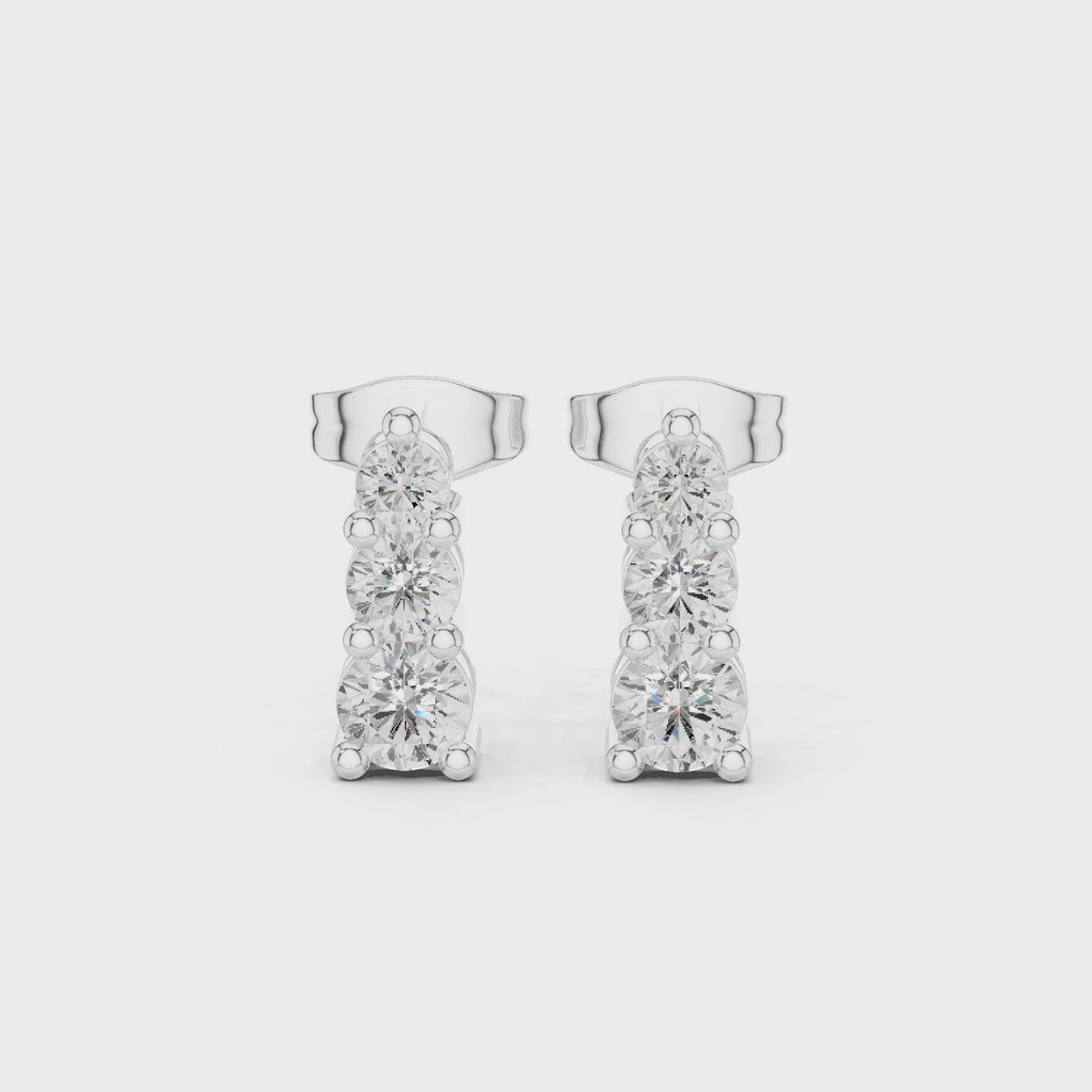 Round lab-grown diamond three stone drop earrings in white gold, 360 degree video