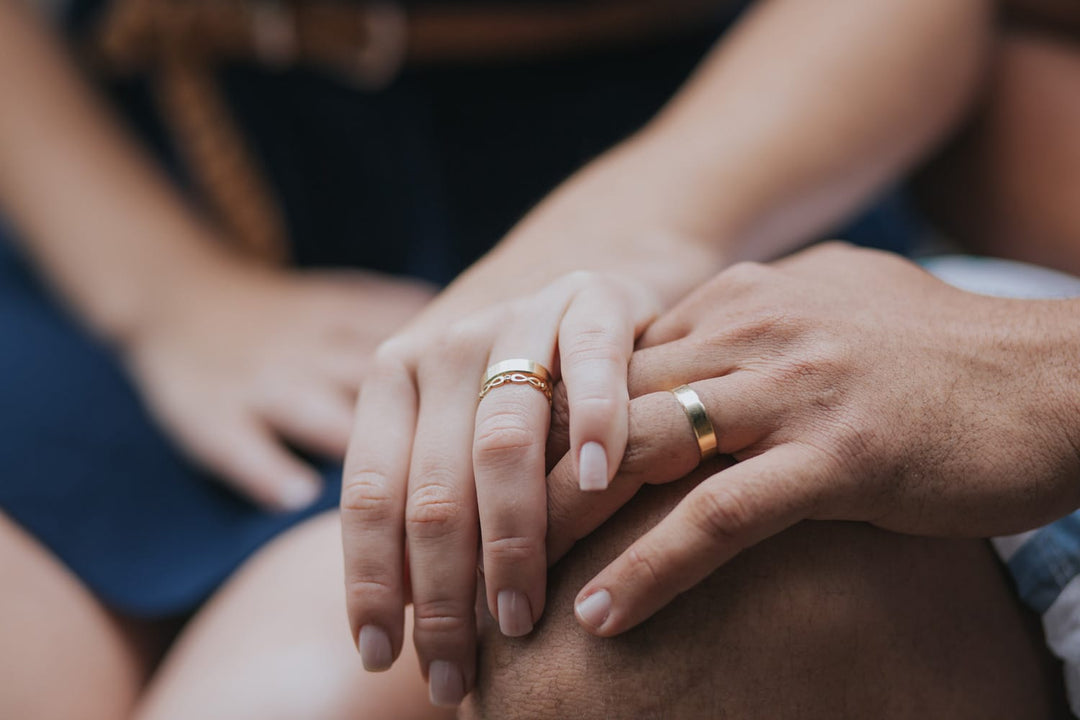 holding hands showing off gold wedding rings